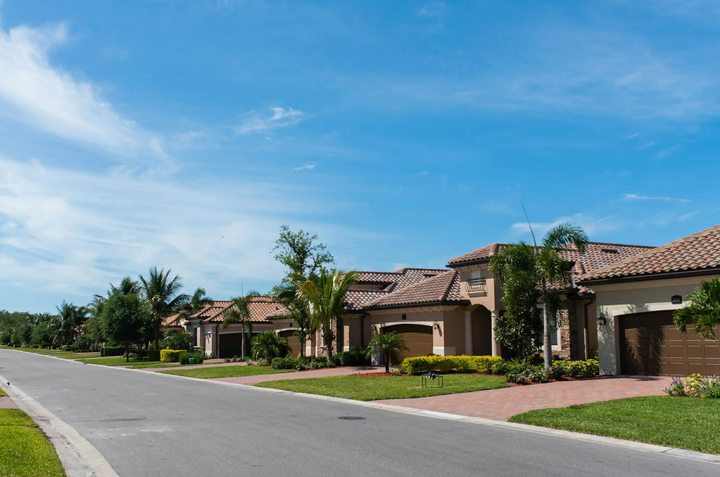 A Florida street with tile-roof homes and palm trees