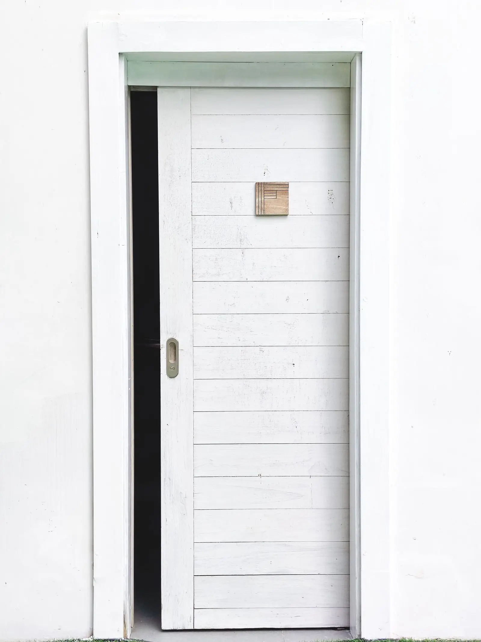 A white interior door partly slid into its wall pocket