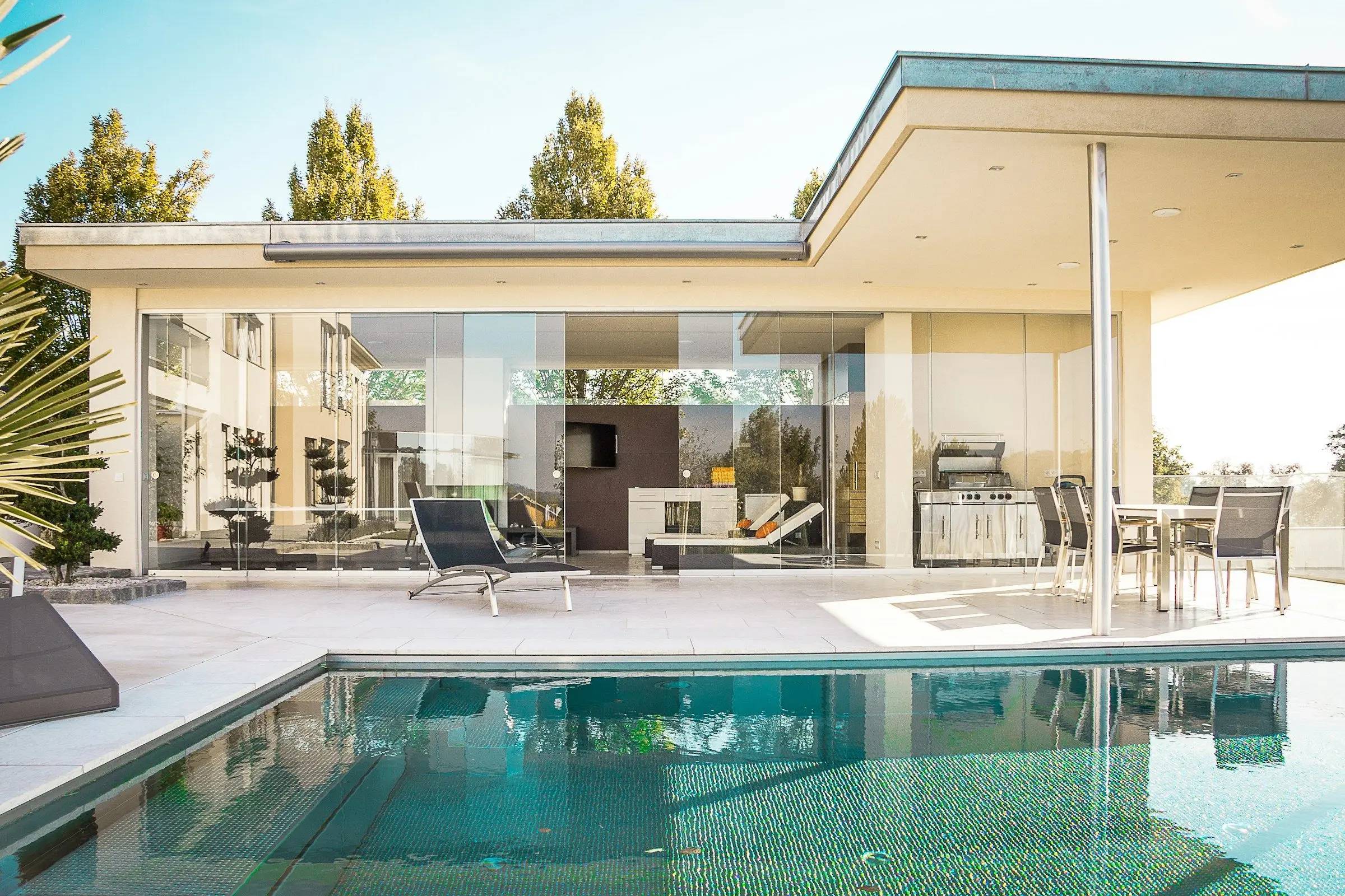 A wall of sliding glass panels opening onto a pool deck