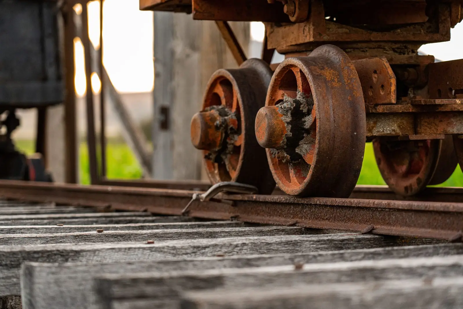 Rusted, grit-caked wheels on a worn rail