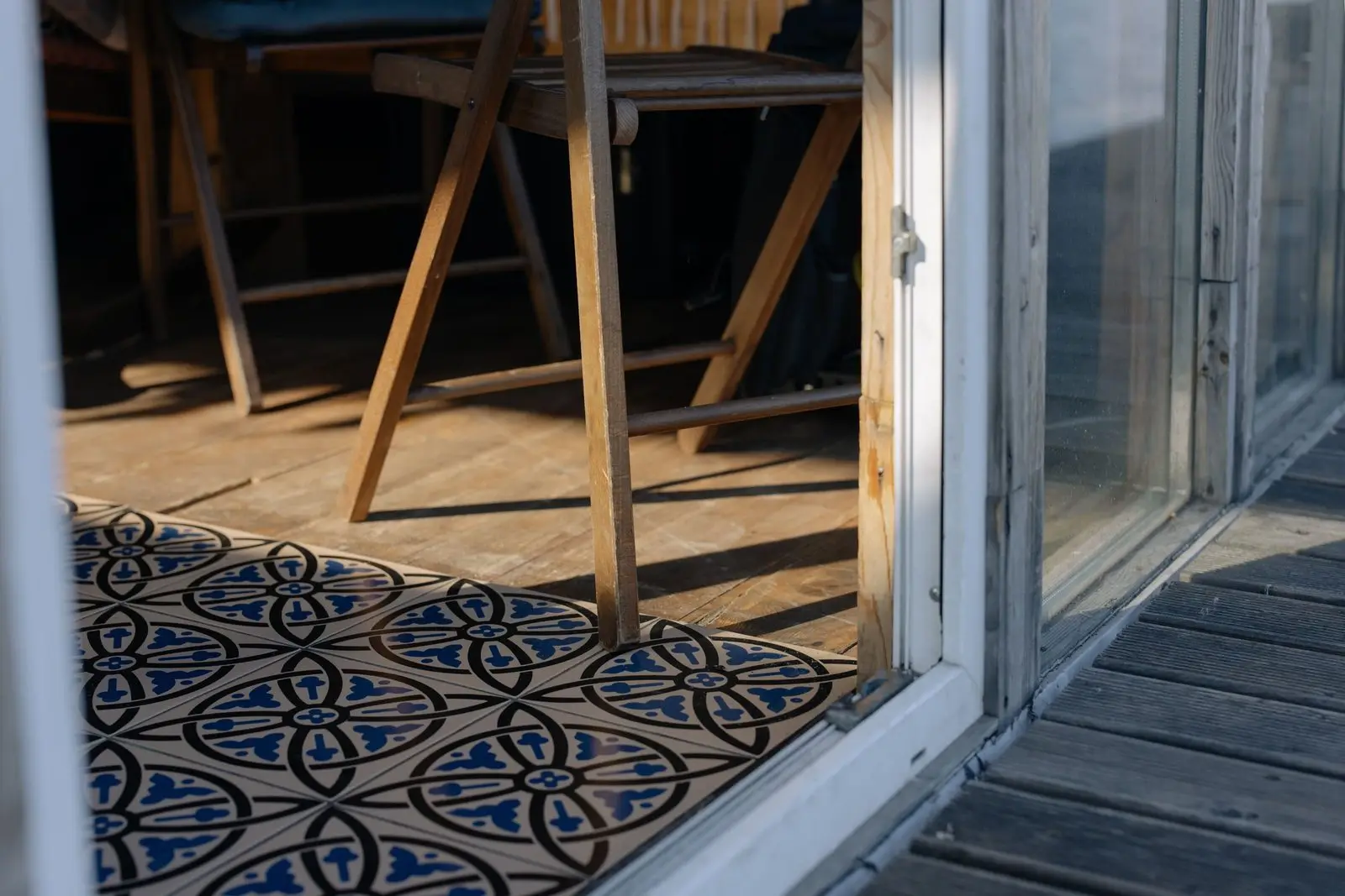A weathered sill and threshold under an open patio door