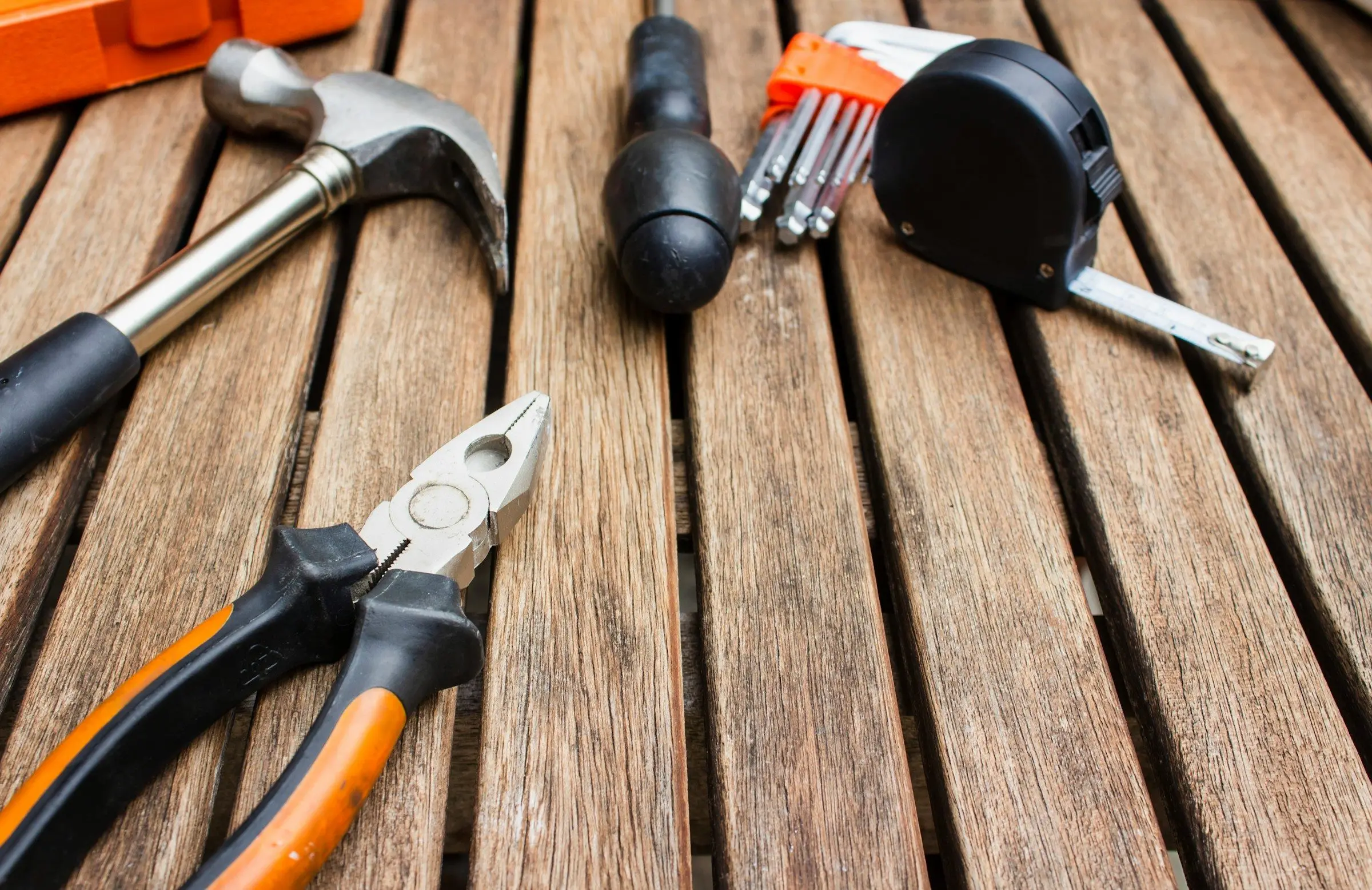 Hand tools laid out on weathered deck boards