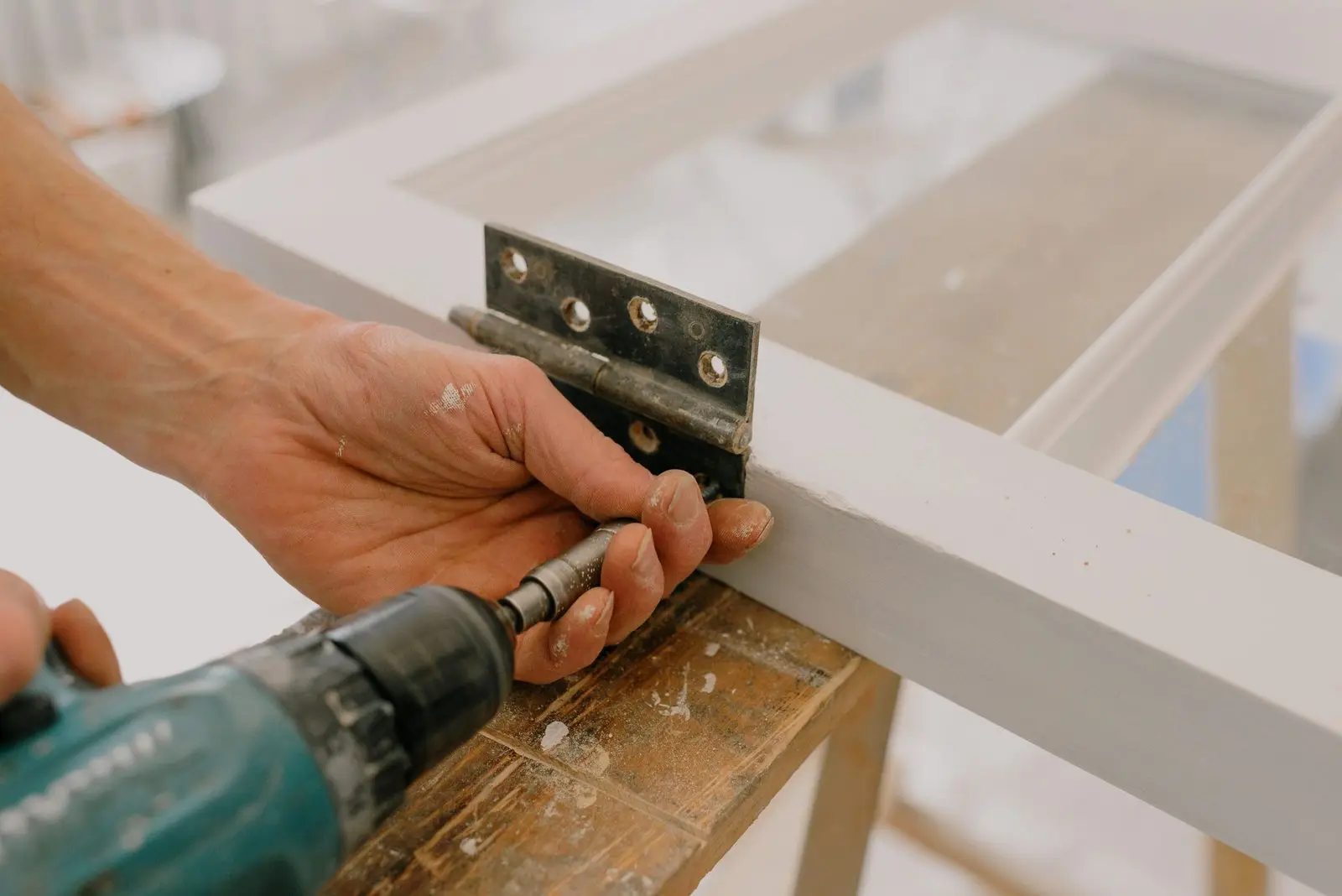 Hands adjusting sliding door hardware with a tool